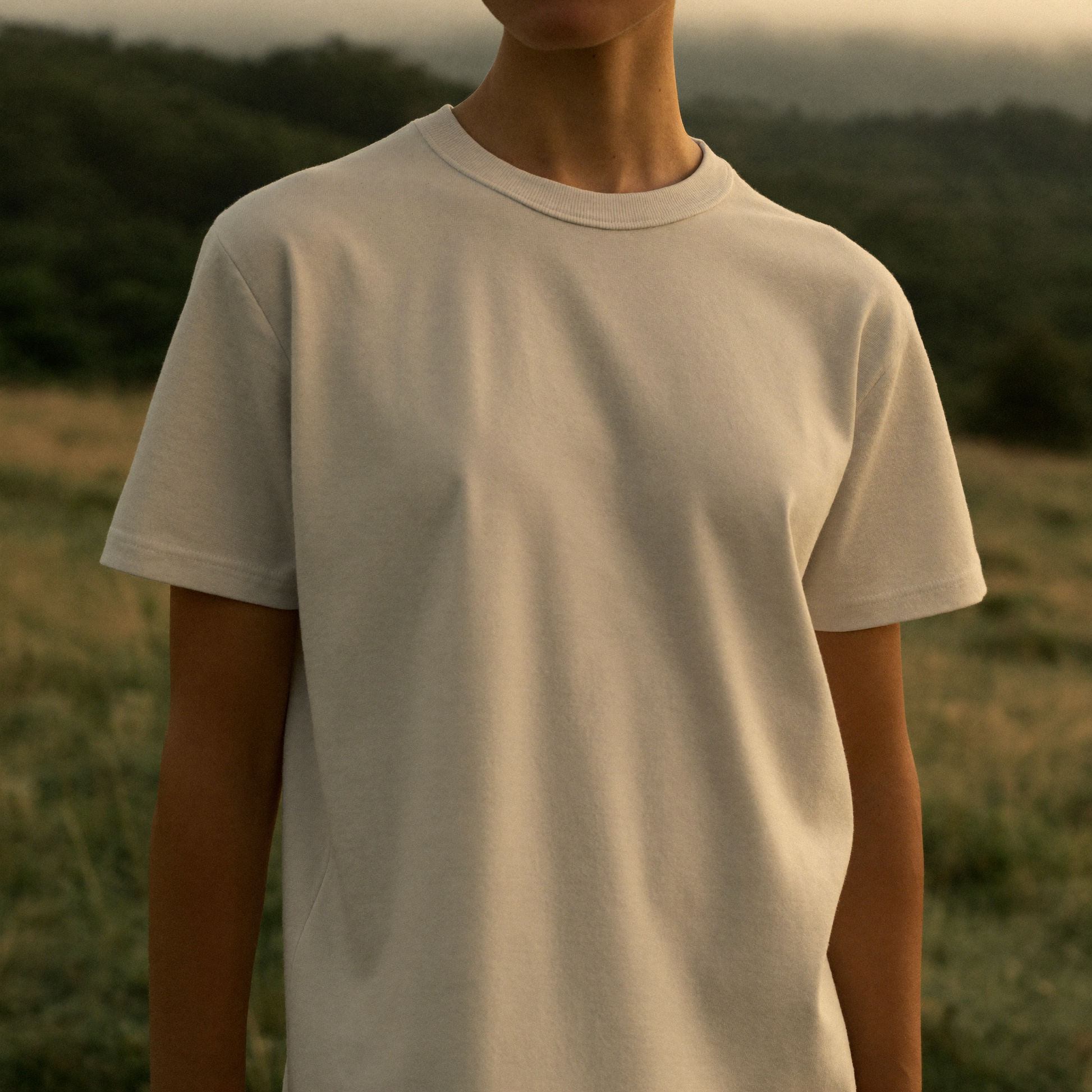 The Basic T worn outdoors in a misty countryside field, Covert Club editorial style